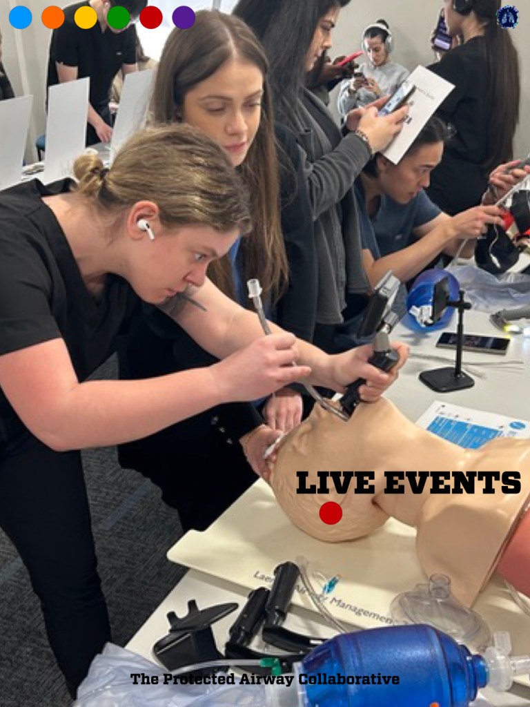Healthcare professionals participating in a hands-on training session, using airway management tools on a mannequin in a classroom setting.